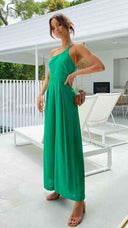 Green asymmetrical strapless jumpsuit with high waistline, front view on patio.