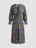 Amelia floral A-line midi wedding guest dress in blue, V-neckline and front twisted-knot waist detail, full front view on white background.