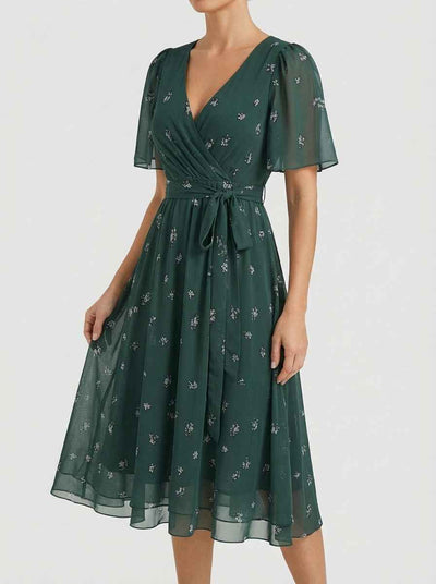 Amelia Flutter Sleeve Floral Midi Dress in deep forest green with shimmer floral sprig print, surplice wrap V-neckline and self-tie waist bow, angled front view.
