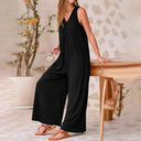 Black baggy V-neck jumpsuit with wide legs and side pockets, angled view.