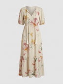 Beatrice Floral V-Neck Maxi Summer Dress in Beige with large-scale floral print, V-neck tassel tie and short puff sleeves, front view.