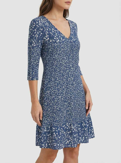 Bella navy blue abstract scatter print mini dress with V-neckline, 3/4 sleeves and ruffled hem, angled side view on model