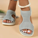 Grey knit slip-on flatform sandals with ruched ankle cuff detail and white cushioned sole, front angled view on beige background.