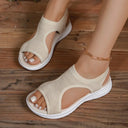 Cream textured knit slip-on flatform sandals with curved cut-out design, worn on feet, angled view.