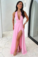 Pink V-neck maxi dress with high slit, worn by a model, angled view on a light background.