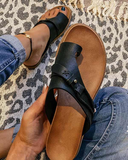 Black toe-ring buckle sandal with tan cushioned footbed, overhead view on neutral background.