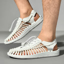 White woven sandals with lace-up closure and cushioned sole, angled front view.