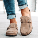 Khaki suede-look closed-toe platform mules with adjustable buckle strap, styled with rolled-cuff jeans, front angled view.