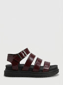 Wine red chunky platform sandals with three horizontal toe straps, adjustable buckle ankle strap and gold chain detail, side view on white background.