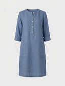 Daisy 3/4 sleeve relaxed shift dress in blue woven, round crew neck, partial button placket, roll-tab sleeves and two front patch pockets, front view.