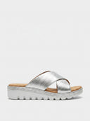 Silver cross-strap espadrille wedge mule sandals with white midsole and tan cushioned footbed, side view.