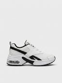 Cushioned women's trainer in White — clean white low-top trainer with smooth synthetic panels, chunky white midsole, and visible air-cushion heel pod, side view.