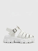 White crocodile-embossed cage flatform platform sandal with lug sole and buckle ankle strap, side view on white background.