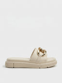 Beige platform slide sandal with chunky gold curb-chain detail on the toe strap, side view on white background.