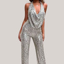 Silver sequin jumpsuit with cowl neck and halter top, front view.