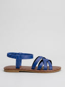 Blue flat sandals with crisscross front straps and elastic ankle strap, side view on white background.
