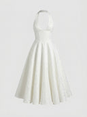 White halterneck mini dress with textured floral pattern, front view.