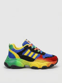Single chunky low-top trainer with thick rainbow sole and multicolour suede-and-mesh upper, side view on white background.