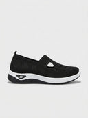Black slip-on orthopaedic trainers with knit upper, T-bar cut-out, and contrast white midsole — UK sizes 6 to 10.