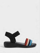 Striped elastic flat sandal in red, beige, navy, and light blue toe strap with black ankle band, side view on white background.