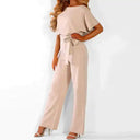 Beige wide-leg jumpsuit with short sleeves and waist tie, angled front view on white background.