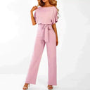 Light pink wide-leg jumpsuit with boat neck and waist tie, front view on white background.