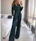 Dark green slim-fit long sleeve jumpsuit with wide legs, front view.