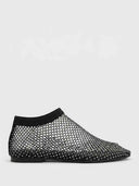 Black rhinestone-studded fishnet mesh flat slip-on shoe with knit ankle band, side view on white background.