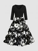 Black V-neck maxi dress with 3/4 sleeves and a white floral print skirt, front view.
