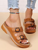 Brown platform wedge sandals with adjustable buckle straps, perforated upper, and cushioned flatform sole, angled front view on neutral background.