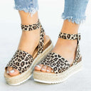 Panther print espadrille flatform sandal with ankle straps and woven jute platform sole, front angled view on foot.