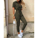 Olive green belted bodycon jumpsuit with decorative buttons, front view on a textured wall background.