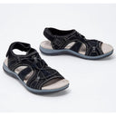 Black closed toe cushioned walking sandals with woven lattice upper and flat grey-white sole, angled pair view.