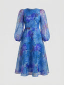 Blue floral mini dress with sheer long sleeves and round neck, front view on white background.
