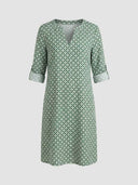 Green and white geometric print mini dress with split-neck and rolled 3/4 sleeves, front view.