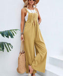 Mustard yellow flared jumpsuit with button straps and pockets, angled view.