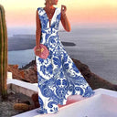 White maxi dress with blue baroque print, V-neck, and flowing skirt, angled view.