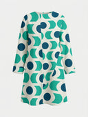 White mini dress with teal and blue geometric pattern, long sleeves, front view.