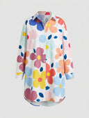 White mini dress with colorful floral print, long sleeves, and collar, front view.
