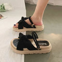 Black ribbed fabric flatform sandals with bow knot detail and beige textured sole, worn on foot from front and sole views.