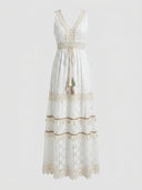 White lace maxi dress with V-neck, waist tie with tassels, and tiered skirt with fringe, front view.