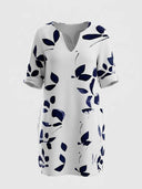 White mini dress with dark blue leaf pattern, V-neck, and cuffed sleeves, front view.
