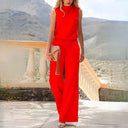 Red sleeveless wide-leg jumpsuit, front view on a patio with mountains.