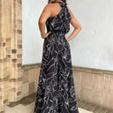 Black jumpsuit with white abstract print, halter neck, and cinched waist, back view.