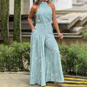 Light blue halter jumpsuit with white abstract print, front view outdoors.
