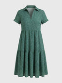 Green polka dot tiered dress with short ruffled sleeves and V-neck, front view.
