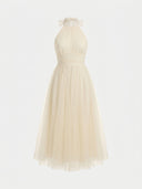 Cream halter neck maxi dress with ruffled collar and tulle skirt, front view.