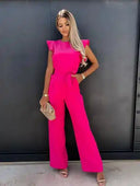 Pink ruffled sleeve jumpsuit with coordinating waist belt, front view against a dark wall.
