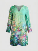 Green mini dress with colorful floral watercolor print, V-neck, long sleeves, front view on gray background.