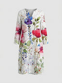 White mini dress with watercolor floral print, long sleeves, and V-neck, front view on a gray background.